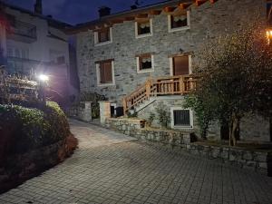un edificio in pietra con un ponte di legno sul lato di Chalet Cà Modest a Grosotto