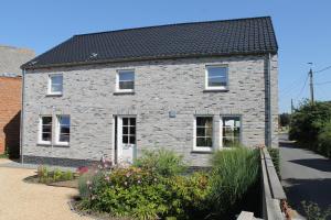 una casa in mattoni con tetto nero di Le Relais de Lou maison d'hôtes 