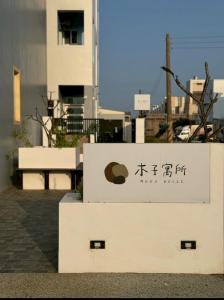 un cartello per un edificio di fronte a un edificio di 木子寓所 Moozhouse a Magong