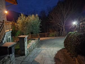 un sentiero in pietra con una recinzione in legno di notte di Chalet Cà Modest a Grosotto