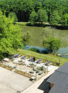 an overhead view of a lake with a group of tables and chairs at Camping Les Rochelles in Prunay-Cassereau