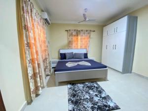 a bedroom with a bed in a room with curtains at Dija Residence in Bijilo