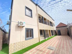 a large white building with a brick courtyard at Dija Residence in Bijilo