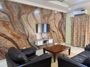 a living room with a wooden wall with a tv at Dija Residence in Bijilo