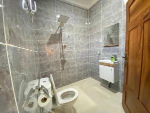 a bathroom with a toilet and a sink and a shower at Dija Residence in Bijilo