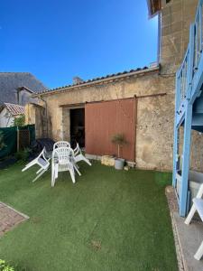a patio with two chairs and a table on the grass at Maison idéale pour visiter Bordeaux in Ambarès-et-Lagrave