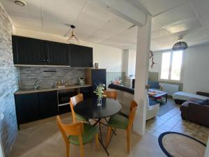 a kitchen and living room with a table and chairs at Maison idéale pour visiter Bordeaux in Ambarès-et-Lagrave