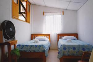 een kamer met twee bedden en een raam bij Hotel Rabin Itzam in Lanquín