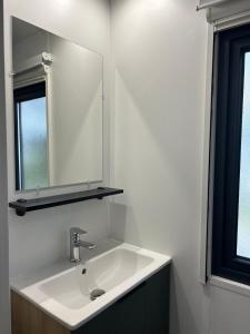 a bathroom with a white sink and a mirror at Panorama Best View in Lauwersoog +13 photos