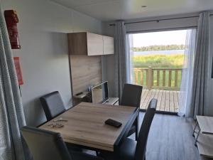 a dining room with a table and chairs and a balcony at Panorama Best View in Lauwersoog