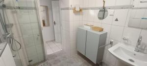 a white bathroom with a shower and a sink at Ferienwohnung Urlaubszeit in Illingen +35 photos