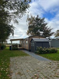 a small house with a garage in a yard at Panorama Best View in Lauwersoog