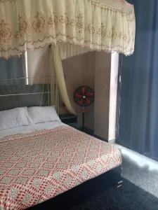 een slaapkamer met een hemelbed en een raam bij Icon Hotel in Kampala