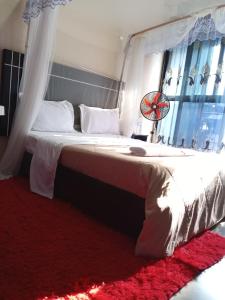 een slaapkamer met een groot wit bed met een raam bij Icon Hotel in Kampala