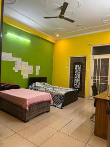 una camera da letto con due letti e una parete verde di Sparkline Girls Hostel a Lucknow