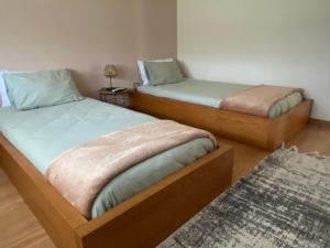 two twin beds in a room with a rug at Casa do Vale Vintém in Condeixa a Nova +81 photos
