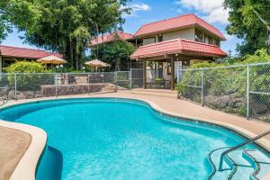 a swimming pool in front of a house at Kona Mansions#301 in Kailua-Kona
