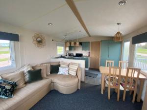 a living room and kitchen with a couch and a table at No 56 Headiton Caravan Park in Banff