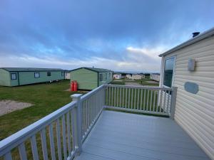 a balcony with a white railing and houses at No 56 Headiton Caravan Park in Banff