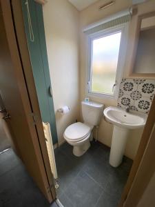 a bathroom with a toilet and a sink at No 56 Headiton Caravan Park in Banff +8 photos