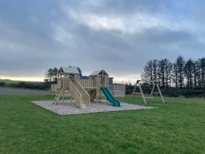 a playground with a slide in a field at No 56 Headiton Caravan Park in Banff