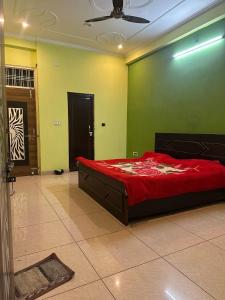 una camera da letto con un grande letto rosso in una parete verde di Sparkline Girls Hostel a Lucknow Altre 9 foto