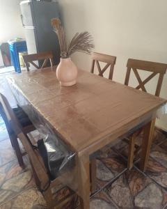 a wooden table with a vase on top of it at Suíte brisa do litoral in Arraial do Cabo