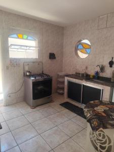 a kitchen with a stove and a sink and a window at Suíte brisa do litoral in Arraial do Cabo