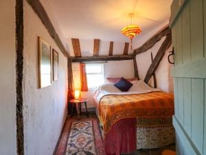 a bedroom with a bed with an orange blanket and a window at Town Farm in Eye
