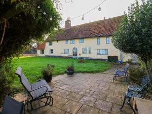 a patio with chairs and a house in the background at Town Farm in Eye