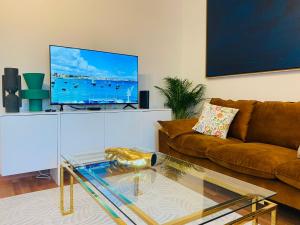 a living room with a couch and a tv at Ocean Gate Palace in Caxias
