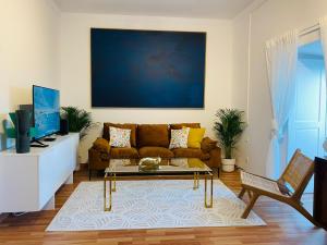 a living room with a couch and a tv at Ocean Gate Palace in Caxias