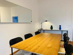 a dining room with a wooden table and black chairs at Ocean Gate Palace in Caxias