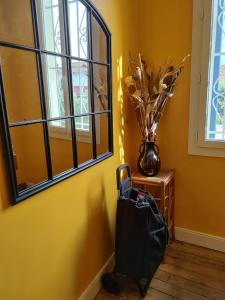 a yellow room with a vase on a table next to a window at Appartement avec Terrasse à Beaurivage in Biarritz