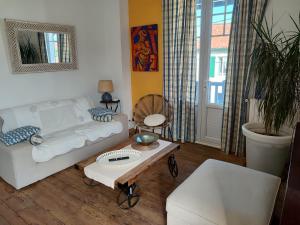 a living room with a white couch and a table at Appartement avec Terrasse à Beaurivage in Biarritz
