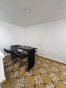 a room with a table and chairs on a tile floor at Hostal Los Robles in Pasto