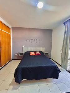 a bedroom with a bed with a black comforter at Espacio Planetaria in Córdoba