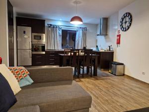 a living room and kitchen with a couch and a table at Estrela do Frade in Maia