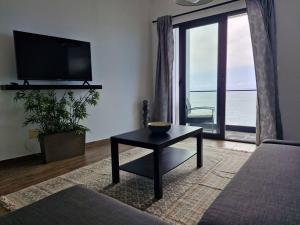 a living room with a table and a large window at Estrela do Frade in Maia