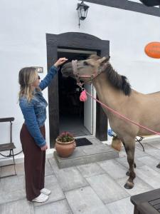 a woman is petting a horse in a pot at Winnica Bursztynowa in Możdżanowo