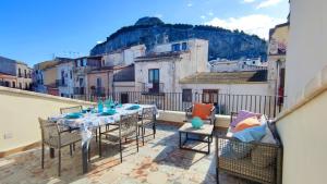 un patio con tavolo e sedie su un balcone di Luxury House a Cefalù