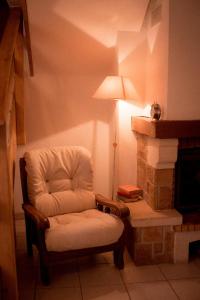 een witte stoel in een kamer met een open haard bij La Ferme du Veyre in Saint-Bonnet-en-Champsaur