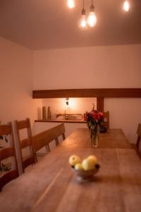 een eettafel met een vaas met bloemen erop bij La Ferme du Veyre in Saint-Bonnet-en-Champsaur