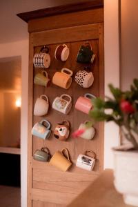 een houten kast gevuld met allerlei verschillende soorten handtassen bij La Ferme du Veyre in Saint-Bonnet-en-Champsaur