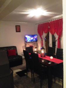 a living room with a table with chairs and a tv at Kuća za odmor Vukas in Kupres