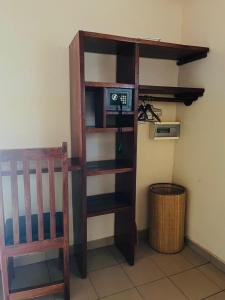 a book shelf with a tv and a chair in a room at Kabacoto Lodges in Darou Rhamane