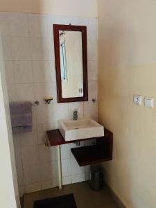 a bathroom with a sink and a mirror at Kabacoto Lodges in Darou Rhamane