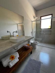 a bathroom with a sink and a toilet at Casa Cris in Itaúnas