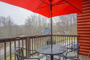 a table and chairs with a red umbrella on a balcony at 2 Br Plus Loft: Hawthorne Valley 4 in Snowshoe
