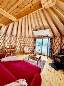 a living room with a red couch in a yurt at Glamping Niebiańska Osada Jurty Dolnośląskie in Polanica-Zdrój